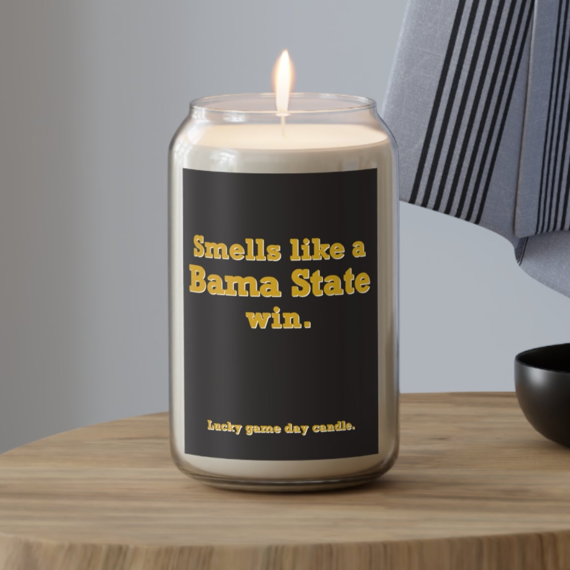 Alabama State candle with text on a wooden table against a neutral background