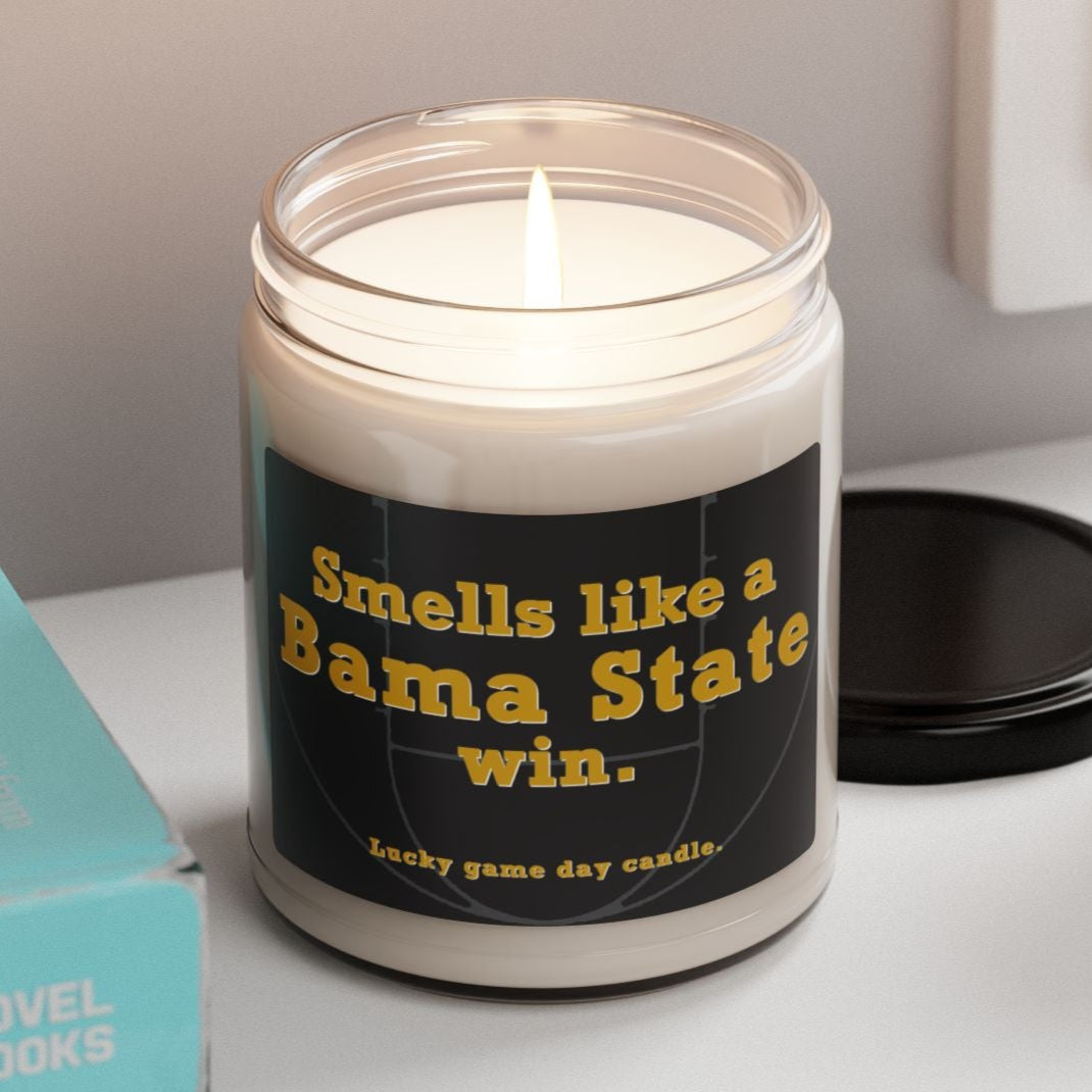 Alabama State candle with a humorous label on a shelf with books and a plant