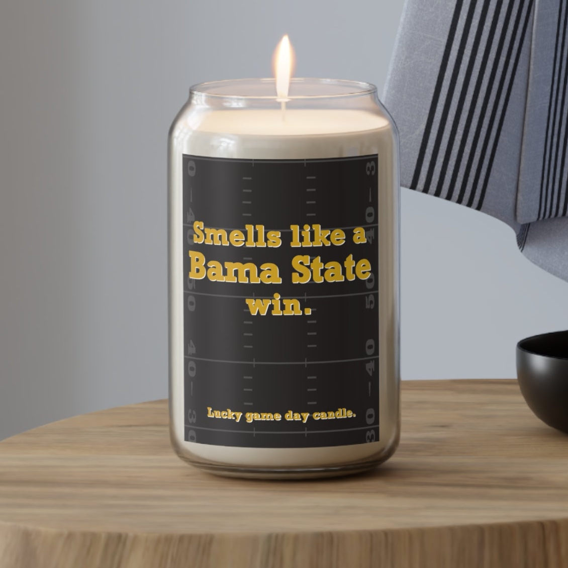 Alabama State candle with text on a wooden table against a neutral background