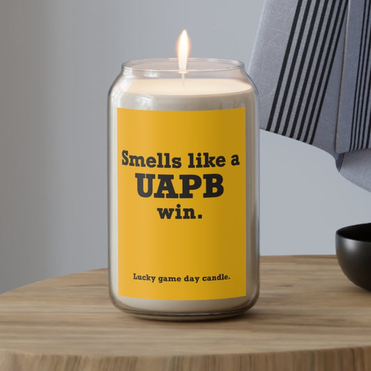 Arkansas Pine-Bluff candle with a yellow label on a wooden table, featuring text and a brand name.