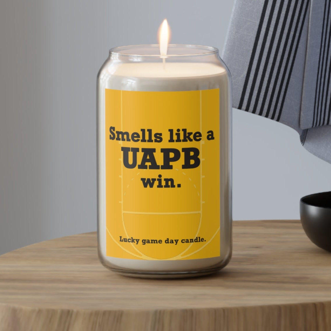 Arkansas Pine-Bluff candle with a yellow label on a wooden table, featuring text.