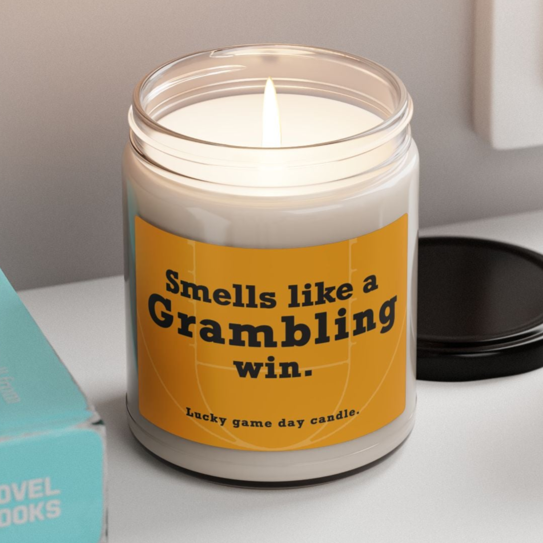 Grambling candle with a humorous label on a shelf with books and a plant