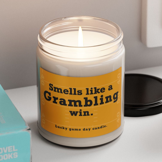 Grambling candle with a humorous label on a shelf with books and a plant