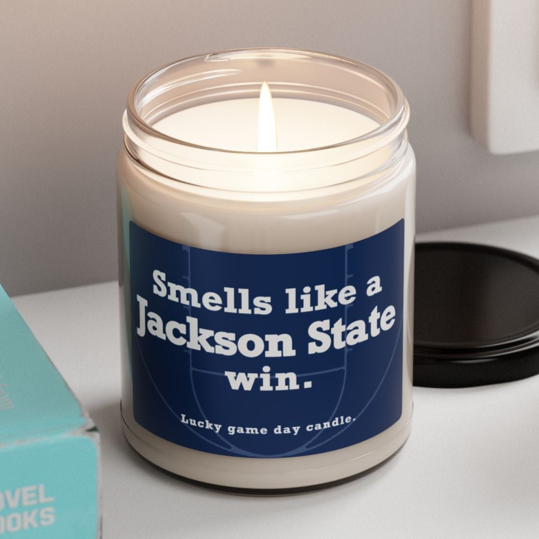 Jackson State candle with 'Smells like a Jackson State win' label on a shelf with books and a plant
