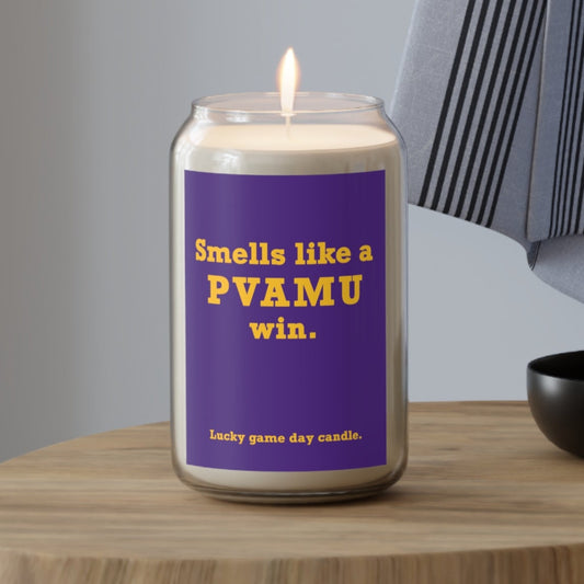 Prairie View A&M candle with a purple label on a wooden table, featuring text.